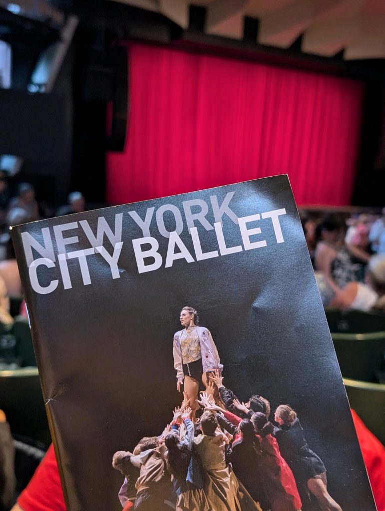 Program for the New York City Ballet show with the stage in the background.